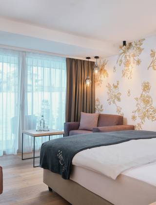 hotel room of the HOCHKÖNIGIN with stylish lamps and noble wallpaper with golden flowers
