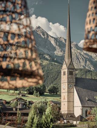 View from the terrace of the HOCHKÖNIGIN to the church of Maria Alm and the surrounding mountains